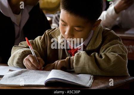 Ragazzo iscritto in Notebook di classe Hongsa Laos Foto Stock