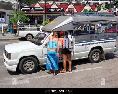 Due giovani donne visitatori negoziare la tariffa in sawngthaew shared ride taxi Ao Nang Beach resort vicino a Krabi Thailandia Foto Stock