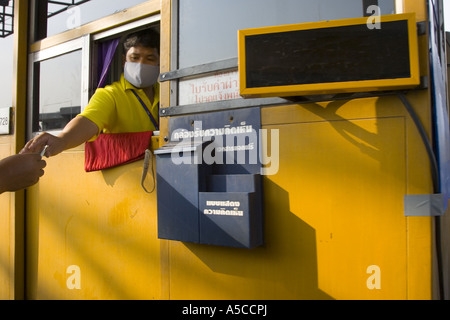 Biglietteria a pagamento nella città di Bangkok, in Thailandia strada che indossa maschere di filtro antinquinamento come protezione contro smog e fumi di scarico dei veicoli. Foto Stock