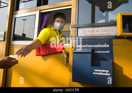 Biglietteria a pagamento nella città di Bangkok, in Thailandia strada che indossa maschere di filtro antinquinamento come protezione contro smog e fumi di scarico dei veicoli. Foto Stock