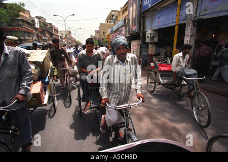 Ciclo di risciò bicicletta driver sulle strade brulicanti di Chandni Chowk area della Vecchia Delhi uno di India s più famosi mercati Foto Stock