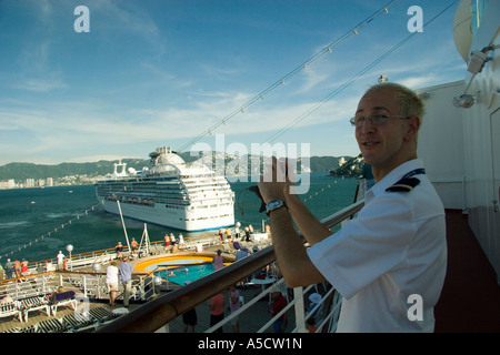 Officer a bordo della Holland America nave da crociera ms Veendam con il Princess Cruises Coral Princess in background al porto Foto Stock