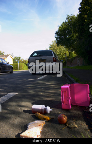 Auto tirata fino a frenare con una caduta o scartato lunchbox suggerendo che il bambino è stato rapito o forse colpito in auto Foto Stock