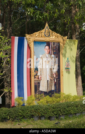 Poster stradale del venerato Re Bhumibol Adulyadej drappeggiati con bandiera nazionale e colori reali Foto Stock