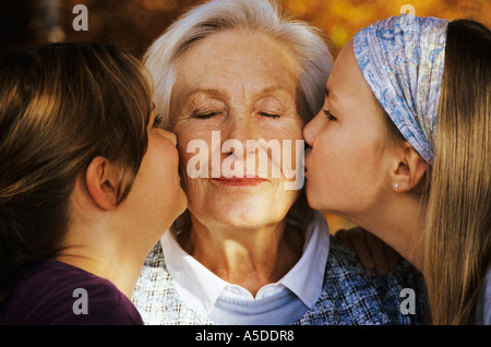 Due ragazze (8-11) baciare la nonna, close-up Foto Stock