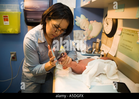 Un giorno il vecchio del bambino in piedi le stampe vengono prese da un tirocinante ostetrica in ospedale Puvirnituq, Baia di Hudson, Northern Quebec, Canada Foto Stock