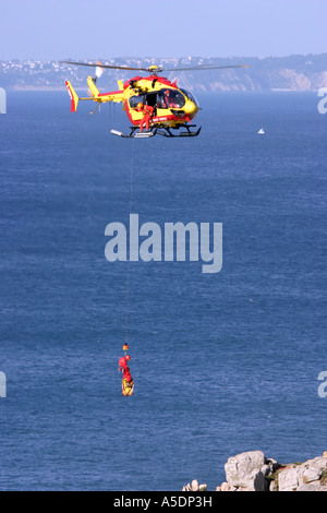 Un Securite Civile elicottero argani di volo a bordo di un incidente, Bretagna Francia Foto Stock