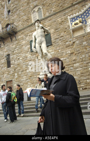 Firenze singolo turista femminile legge guida nella parte anteriore della statua del David Firenze Toscana Italia Foto Stock