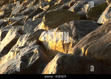 Texture e forme di grandi massi che formano la base di un significativo sea wall difesa Robin cappe Bay nel North Yorkshire Foto Stock