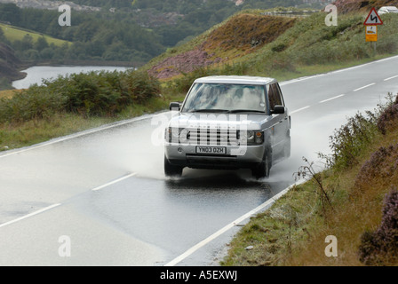 Range Rover attraverso gli spruzzi di acqua su Snake Pass nel Derbyshire Foto Stock