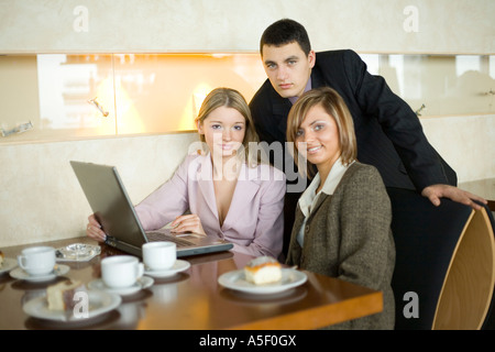 Gruppo di persone a Cofe tavolo portatile con poca profondità di messa a fuoco sulla donna s in camicia rosa faccia Foto Stock