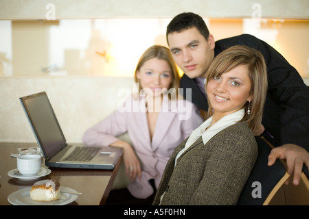 Gruppo di persone a Cofe Tabella con laptop a breve la profondità della messa a fuoco in prima persona faccia s Foto Stock