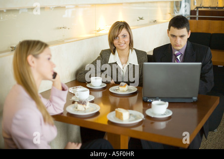 Gruppo di persone a Cofe tavolo portatile con poca profondità di messa a fuoco sulla donna s in faccia centrale Foto Stock