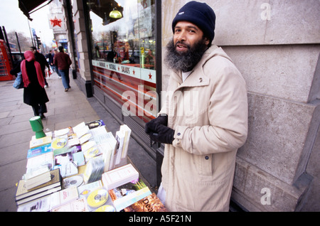 Un uomo vendita libri e cd su strada Foto Stock