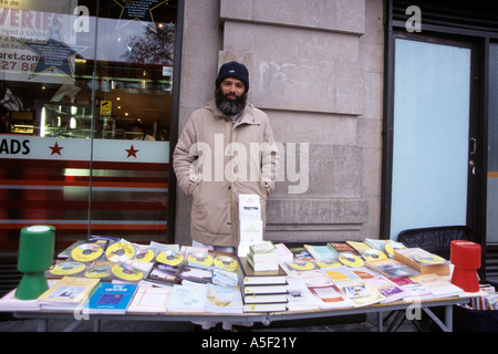 Un uomo vendita libri e cd su strada Foto Stock