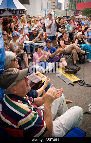 Una piccola folla di tifosi jazz battete le mani durante la visione di una performance su un palco esterno al Jazz Festival di Montreal. Foto Stock