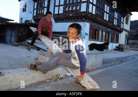 Due ragazzi bhutanesi giocando su altalena, Paro, Bhutan Foto Stock