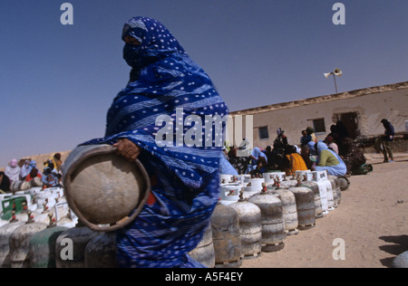 La gente del campo profughi Saharawi a Tindouf Algeria occidentale la raccolta di bottiglie di gas Foto Stock