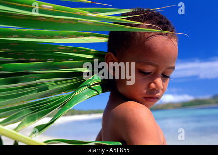 Ragazzo giovane e palm frond nelle isole Figi Oceano Pacifico del Sud Foto Stock