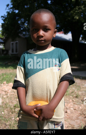 Zanzibar: piccolo ragazzo tenendo un mango in Stonetown, Zanzibar, Tanzania Foto Stock