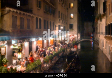 Soft focus colpo di cena presso una banca Canale di Beagle ristorante di notte, San Marco, Venezia, Veneto, Italia Foto Stock