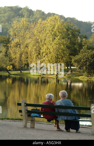 TouristsMBF1801 due anziane signore francese rilassarsi per una sessione di conversazione testuale su una panchina nel parco lungo il fiume Dordogne Foto Stock