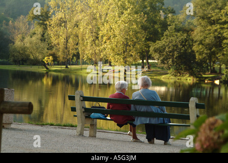 TouristsMBF1802 due anziane signore francese rilassarsi per una sessione di conversazione testuale su una panchina nel parco lungo il fiume Dordogne Foto Stock