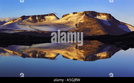 Al mattino presto luce sull'Fannaraken picchi con uno specchio di riflessione come in un lago glaciale, Norvegia, Jotunheimen NP Foto Stock