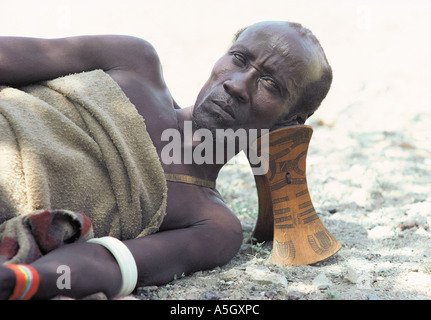 Turkana uomo con un collo tradizionale sgabello per proteggere il suo taglio di capelli di argilla Suguta Valley nel nord del Kenya Africa orientale Foto Stock