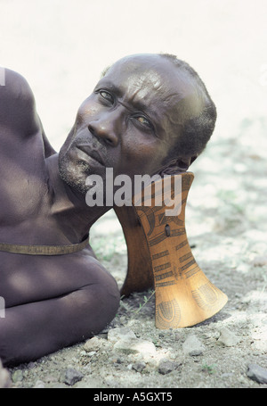 Turkana uomo con un collo tradizionale sgabello per proteggere il suo taglio di capelli di argilla Suguta Valley nel nord del Kenya Africa orientale Foto Stock