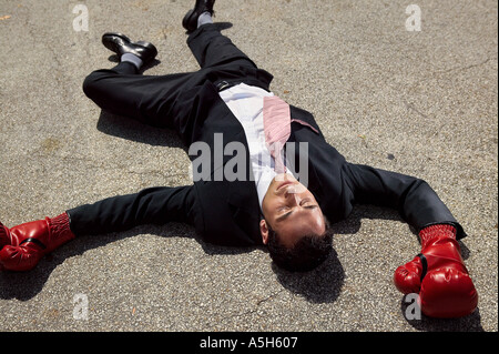 Imprenditore inconscio sul pavimento Foto Stock