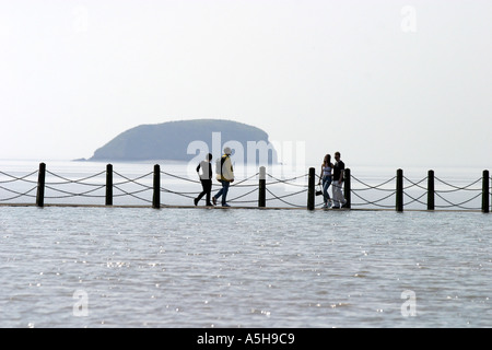 Coppie giovani a piedi lungo la passeggiata del lago marino in Weston super Mare e sale fino al centro Foto Stock