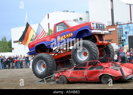 Monster truck frantumazione di altre due vetture Foto Stock