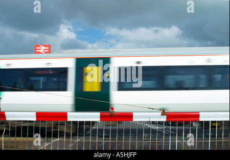 Treno in accelerazione a Ford Station Level Crossing a Sussex, Regno Unito. Foto Stock