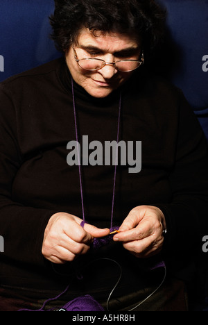 Ritirato lady,si siede e maglieria una sciarpa Foto Stock