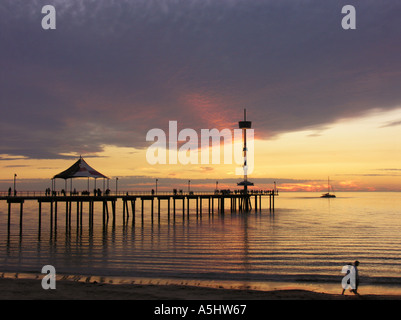 Pontile con coppia camminando sulla spiaggia al tramonto Brighton Adelaide Australia del Sud Foto Stock