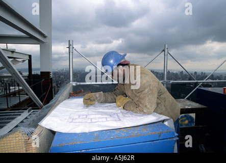 Saldatore guarda oltre il blueprint nella parte superiore del nuovo Random House Building a 1745 Broadway a New York City Foto Stock