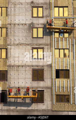 I lavoratori in culle sul lato dell'edificio Foto Stock