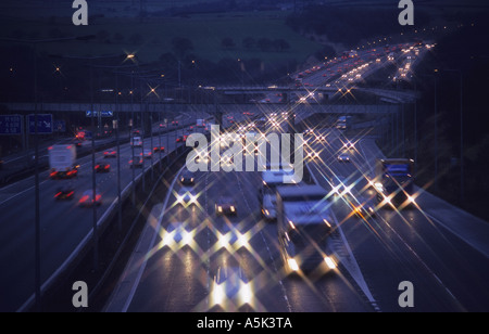 Fari dei veicoli che viaggiano sulla autostrada M62 al crepuscolo Yorkshire Regno Unito Foto Stock