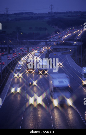 Fari dei veicoli che viaggiano sulla autostrada M62 al crepuscolo Yorkshire Regno Unito Foto Stock