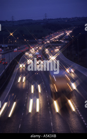 I sentieri dei fari dei veicoli che viaggiano sulla autostrada M62 al crepuscolo Yorkshire Regno Unito Foto Stock