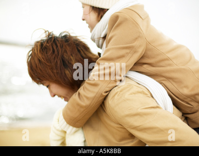 Giovane donna cavallo trasportato su giovane uomo Foto Stock