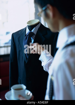 Uomo asiatico nel controllo della sua cravatta Foto Stock