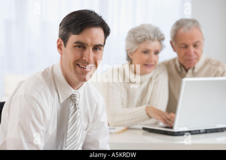 Ritratto di imprenditore con coppia senior in background Foto Stock