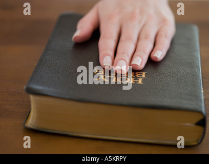 La donna nella sua mano sulla Bibbia Foto Stock