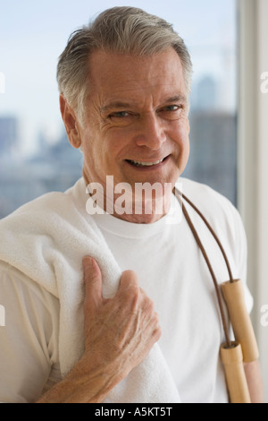 Ritratto di uomo senior holding salto con la corda sulla spalla Foto Stock