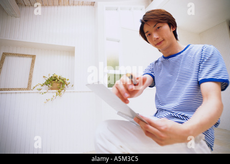 Uomo asiatico puntando una penna con la videocamera Foto Stock