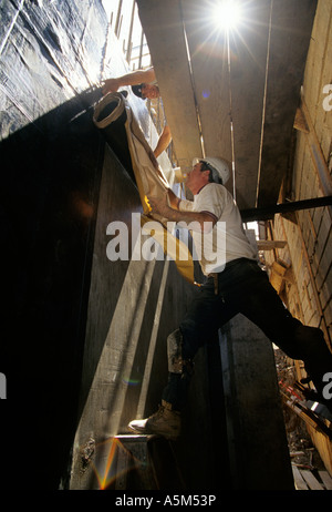 Lavoratori installare W R Grace Bituthene membrana impermeabile su muri di fondazione nel nuovo Random House edificio a 11745 Broadway Foto Stock