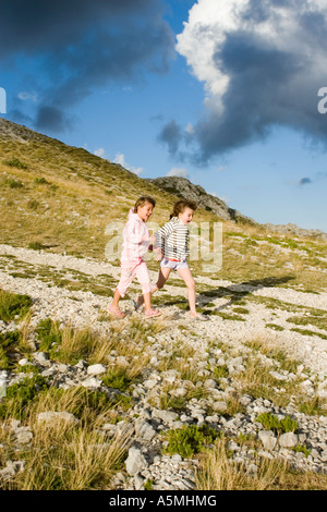 Le ragazze in esecuzione su giù per la collina Foto Stock