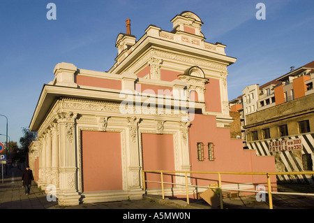 Edificio neoclassico rosa in Garbary Street a Poznan, Polonia. Architettura storica decorata con dettagli decorativi bianchi e un cielo blu. Foto Stock